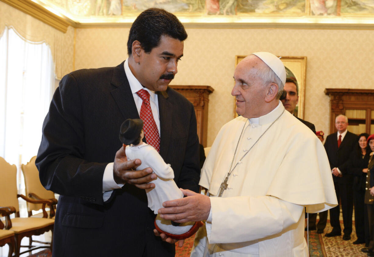 FILE - Venezuelan President Nicolas Maduro, left, gives Pope Francis a statuette of Dr. Jose Gregorio Hernandez, a popular figure amongst Venezuelans, at the Vatican on June 17, 2012. Pope Francis said Venezuela is &ldquo;living a critical situation&rdquo; in his traditional homily Sunday, August 4, 2024, at the Vatican.