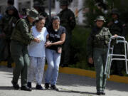 Military personnel help assist an elderly voter during the presidential election in Caracas, Venezuela, Sunday, July 28, 2024.