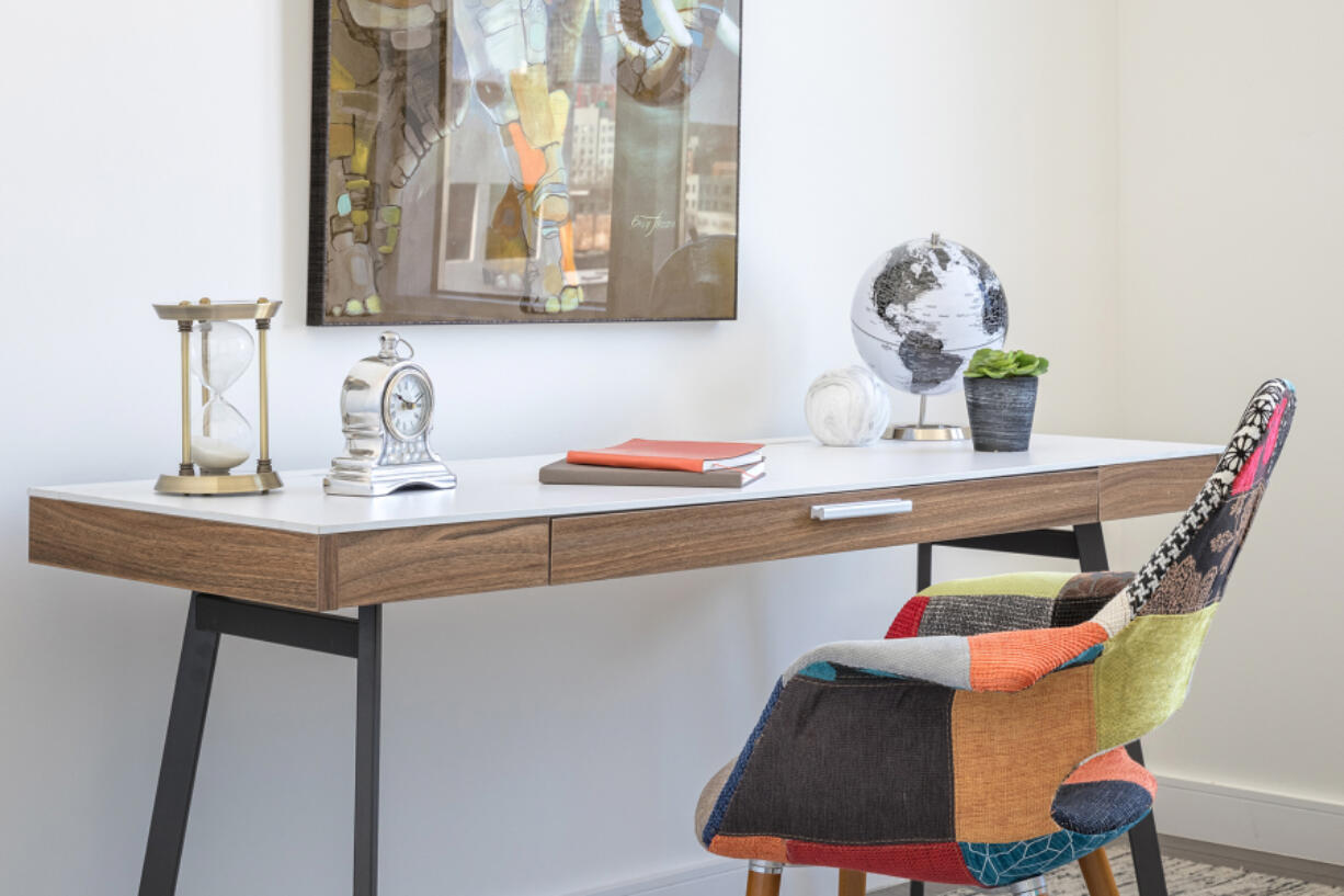 Artwork and creative accents including a patchwork inspired desk chair, helps to make this office feel festive.