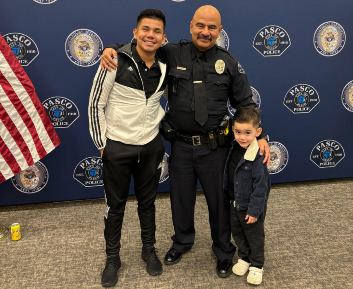 Victor Manuel Arzate poses with his son and retired officer Raymond Aparicio, who mentored Arzate growing up.