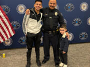 Victor Manuel Arzate poses with his son and retired officer Raymond Aparicio, who mentored Arzate growing up.