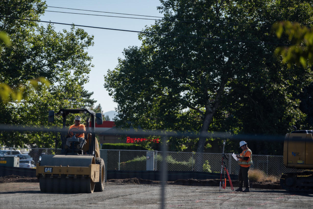 Construction workers make way for new businesses near New Seasons Market in Fisher&rsquo;s Landing. The construction industry in Clark County has lost nearly 1,000 jobs since last summer.