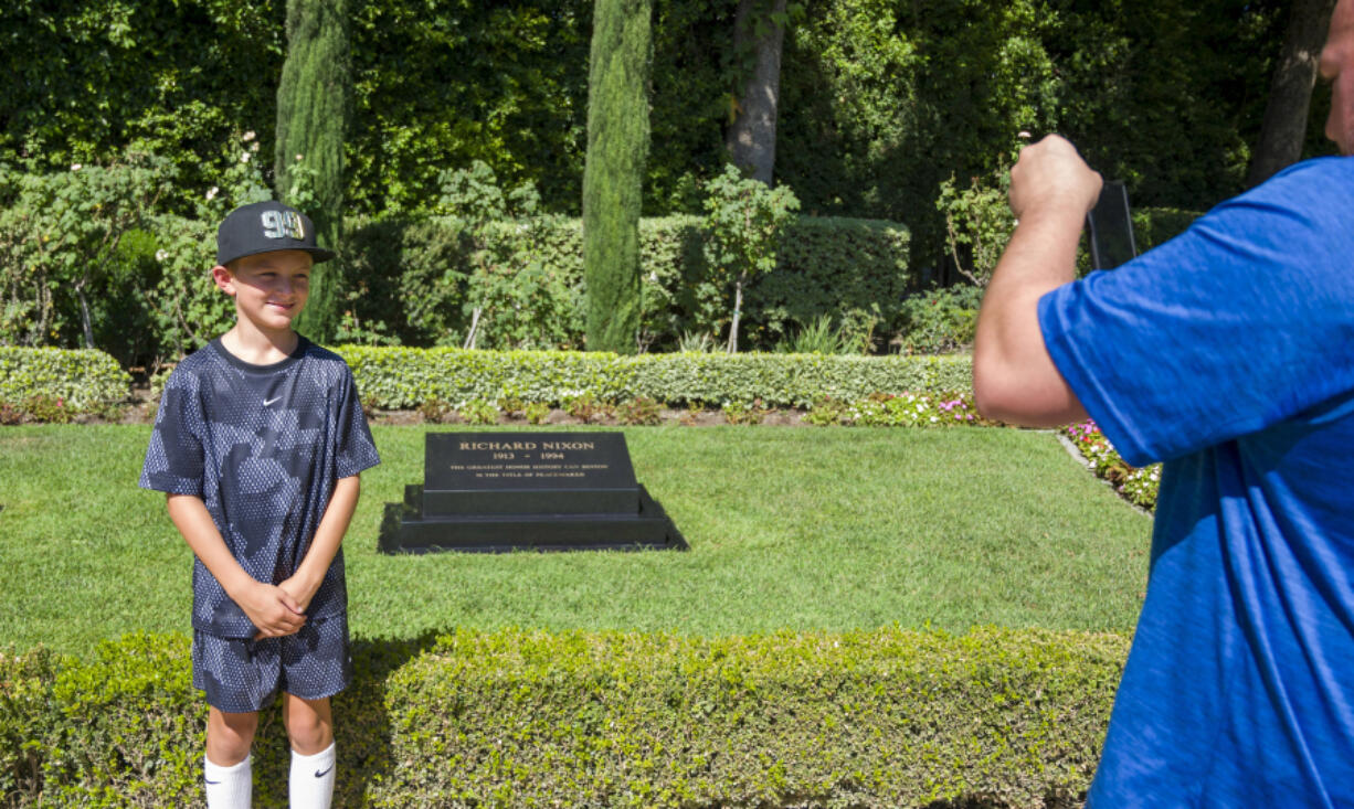 Henry Fallon, 10, left, has his photo take Aug. 5 by his father TJ near the gravesite of President Richard Nixon at The Richard Nixon Library &amp; Museum in Yorba Linda, Calif.