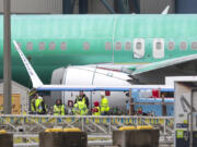 Workers are pictured next to an unpainted 737 aircraft and unattached wing with the Ryanair logo as Boeing&#039;s 737 factory teams hold the first day of a &quot;Quality Stand Down&quot; for the 737 program at Boeing&#039;s factory in Renton, Washington, on Jan. 25, 2024.