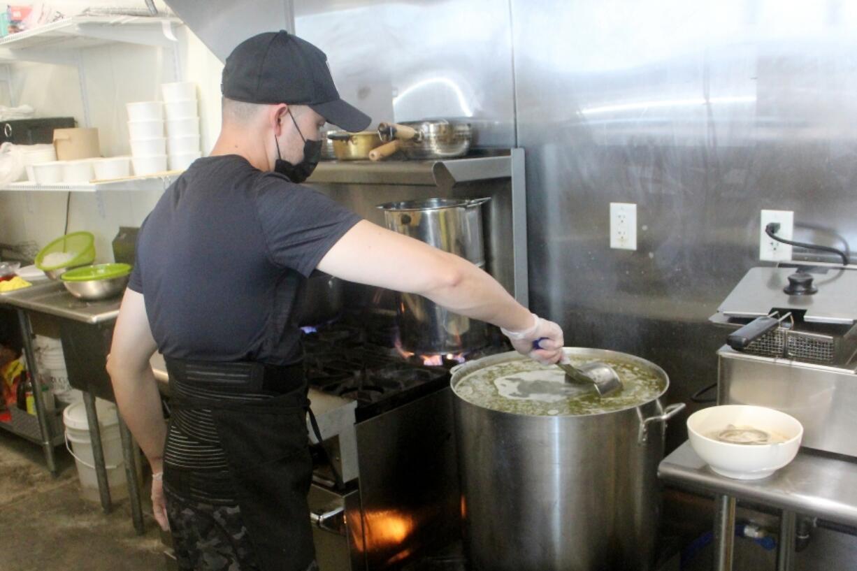 Danglicious Vietnamese Kitchen cook Don Dang stirs soup Aug. 29 in the new downtown Washougal restaurant.