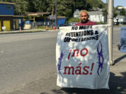 An activist with La Resistencia holds up a protest sign during a press conference about &ldquo;The Border is Everywhere&rdquo; UW Center for Human Rights report outside of the Tukwila Department of Homeland Security building. Sept. 5, 2024.