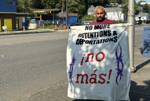 An activist with La Resistencia holds up a protest sign during a press conference about &ldquo;The Border is Everywhere&rdquo; UW Center for Human Rights report outside of the Tukwila Department of Homeland Security building. Sept. 5, 2024.