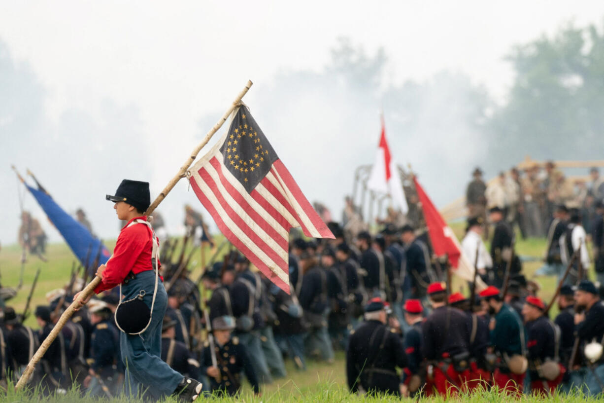 A child reenactor carries a flag during the 160th reenactment of the Battle of Gettysburg, at Daniel Lady Farm in Gettysburg, Pennsylvania, on June 30, 2023. The production of Kathryn Bigelow&Ccedil;&fnof;&Uacute;s upcoming Netflix feature wanted to use the reenactment as background.