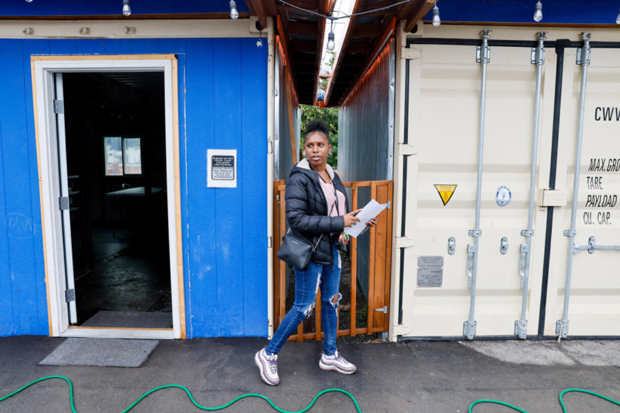 Case manager Johnnaya Banks walks between a larger community space, left, and the kitchen, at the Henderson Village tiny houses in Rainier Beach, Monday, July 29, 2024. Banks&Ccedil;&fnof;&Ugrave; salary is partially paid for by federal Medicaid funding that has been recently paused.