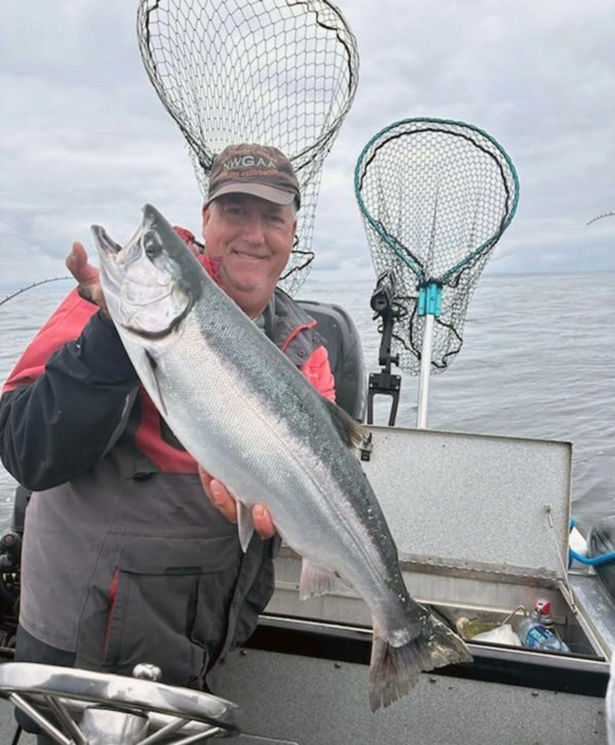 Fishing guide Bob Rees holds a dandy coho taken in the estuary. Anglers can now keep one Chinook at Buoy 10 as part of a three-fish limit.