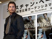 Christian Bale poses beside posters of his film &ldquo;American Psycho&rdquo; after a press conference at a hotel in Tokyo on Jan. 24, 2001.