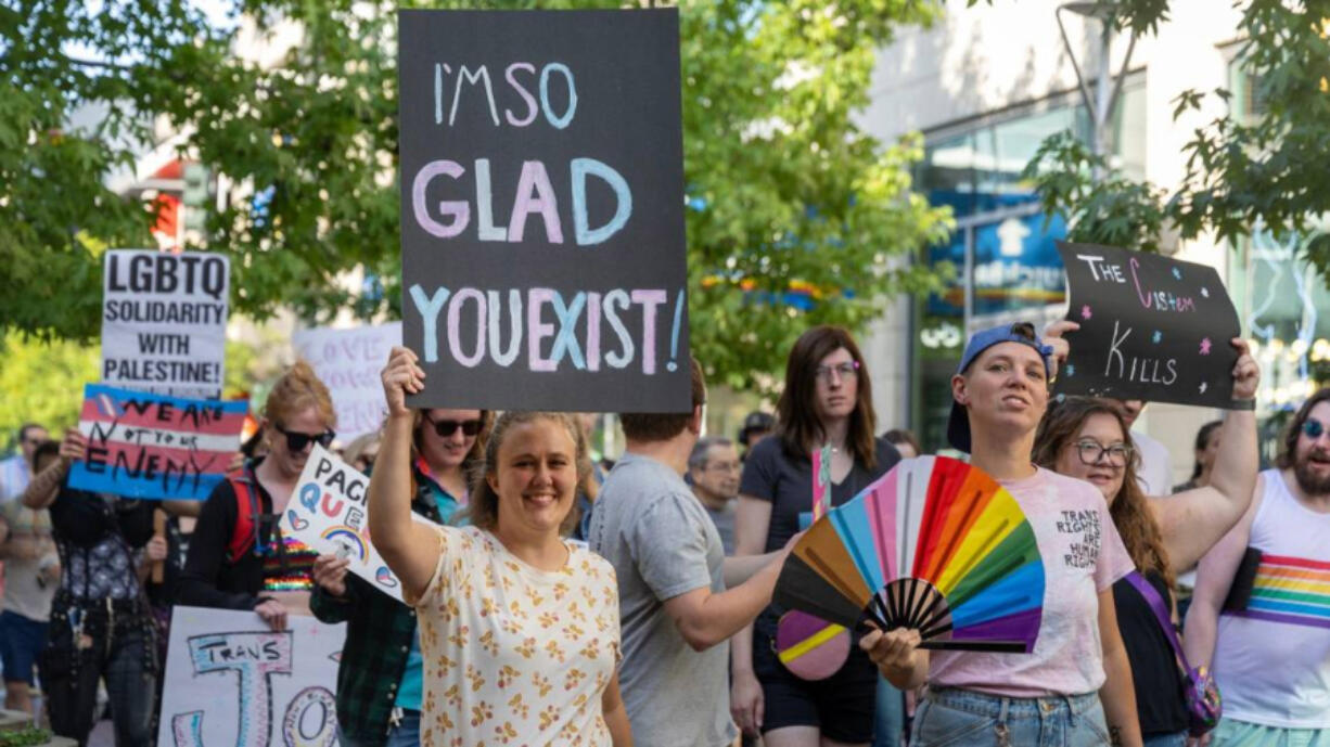 Demonstrators carry signs and flags in support of transgender people during the Trans March on Friday in Boise, Idaho.