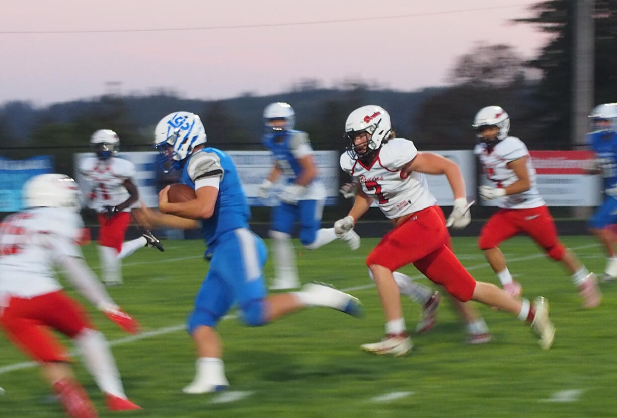 La Center senior quarterback Wyatt Eiesland, left, outruns Columbia's Kai Brasuell (7) for yardage in the first half of the Trico League football opener on Friday, Sept. 20, 2024, at La Center Community Stadium. La Center won the game 61-0.