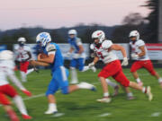 La Center senior quarterback Wyatt Eiesland, left, outruns Columbia's Kai Brasuell (7) for yardage in the first half of the Trico League football opener on Friday, Sept. 20, 2024, at La Center Community Stadium. La Center won the game 61-0.