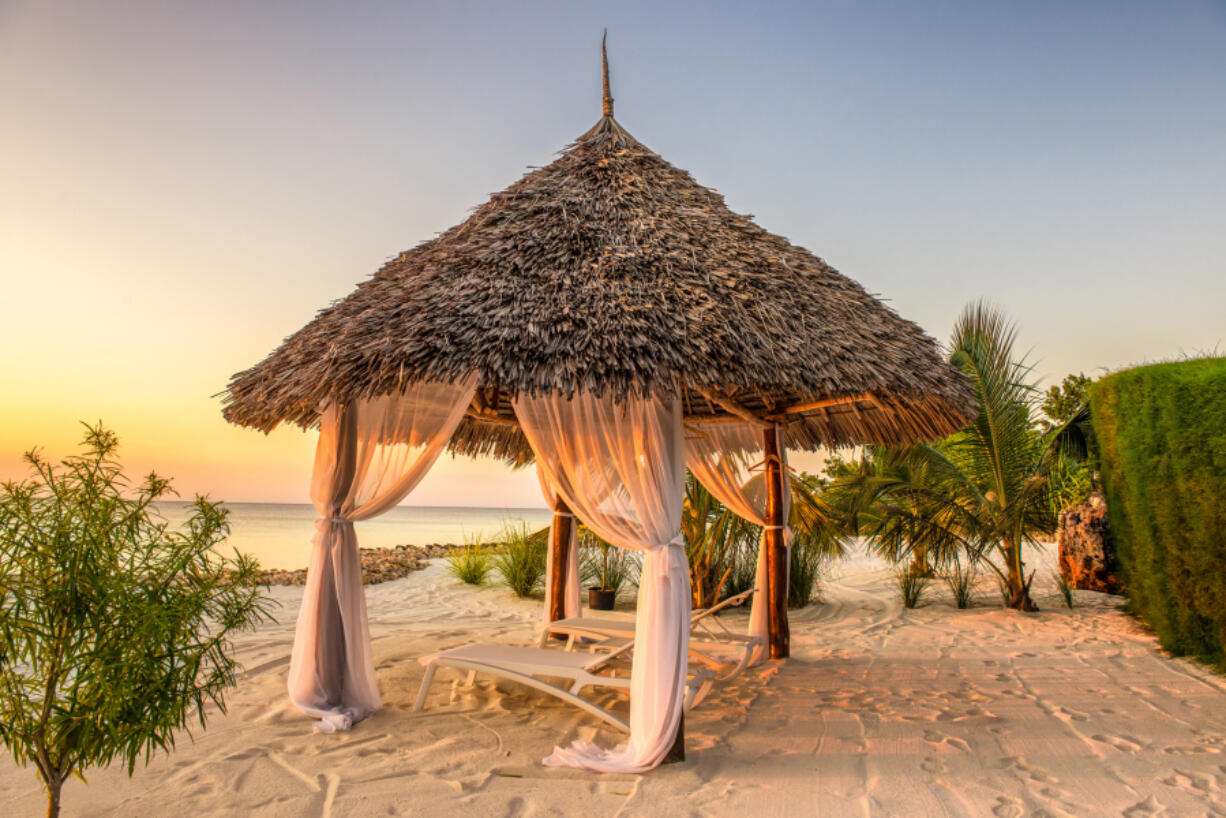 Beach lounge chairs at sunset, Zanzibar, Tanzania.