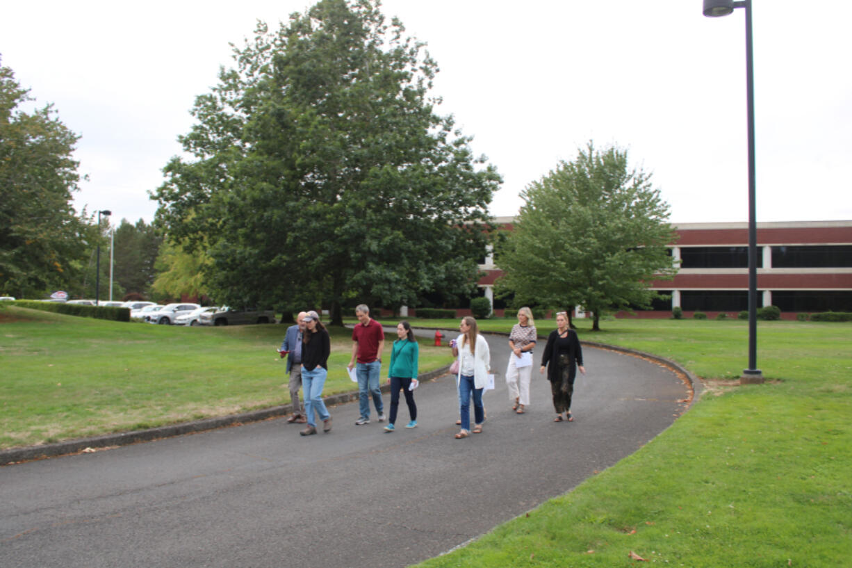 Jasen McEathron, far left, the Camas School District&rsquo;s director of business services, leads a group of community members and other stakeholders on a tour of the district&rsquo;s &ldquo;Leadbetter campus&rdquo; on Sept. 10. The campus, located off Northwest Leadbetter Drive and Northwest Lake Road, includes the former UL building (pictured), parking lots, green space and the nearby Skyridge Middle School campus.