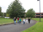 Jasen McEathron, far left, the Camas School District&rsquo;s director of business services, leads a group of community members and other stakeholders on a tour of the district&rsquo;s &ldquo;Leadbetter campus&rdquo; on Sept. 10. The campus, located off Northwest Leadbetter Drive and Northwest Lake Road, includes the former UL building (pictured), parking lots, green space and the nearby Skyridge Middle School campus.