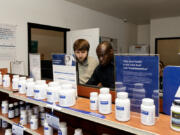 Then-intern Ben Madson and Pharmacist Ike Ekeya of Vancouver work together at Square Care Medical &amp; Pharmacy on July 18, 2023.