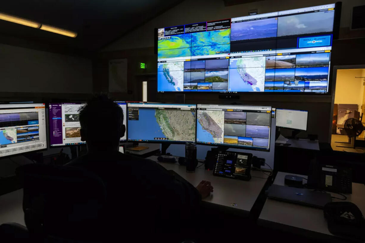 Scott Slumpff of the California Department of Forestry and Fire Protection monitors computer screens last year that depict provide views of wildfire camera systems throughout the state at the Southern California Geographic Area Coordination Center in Moreno Valley, Calif.