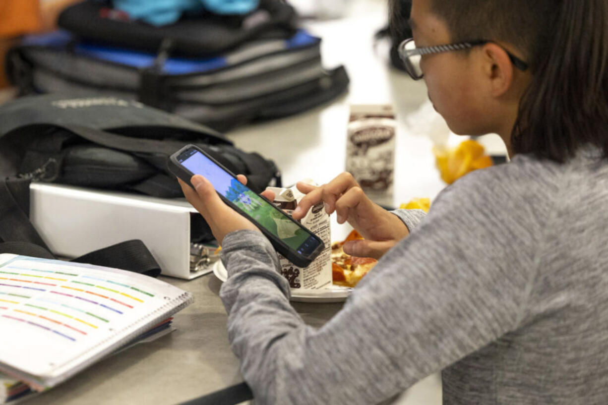 A student uses a smart phone during their lunch break at Goodman Middle School, which allows phones at lunch but otherwise has a district-wide ban, on Monday, Sept. 9, 2024 in Gig Harbor.