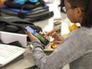 A student uses a smart phone during their lunch break at Goodman Middle School, which allows phones at lunch but otherwise has a district-wide ban, on Monday, Sept. 9, 2024 in Gig Harbor.