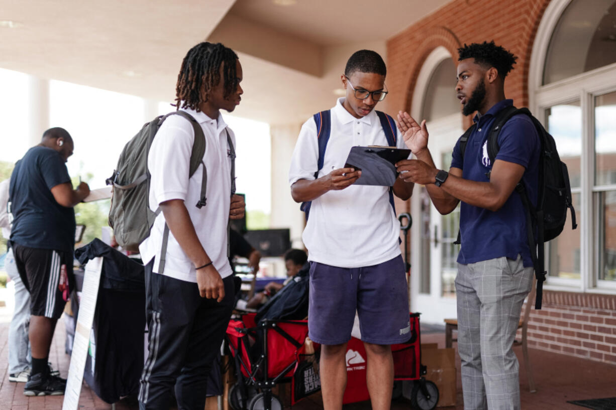 Marchellos Scott, right, helps Morehouse College students fill out a voter registration form at a college registration booth on Aug. 19, 2024, in Atlanta. Scott, 21, a student organizer at the college -- a private, historically Black university in Atlanta for men -- agreed that the mood &ldquo;really shifted&rdquo; with a younger Kamala Harris at the top of the Democratic ticket. &ldquo;We immediately stepped up and threw support behind her,&rdquo; Scott said. He has since been helping to drive student voter registration and plans to organize transport to polling stations on election day.