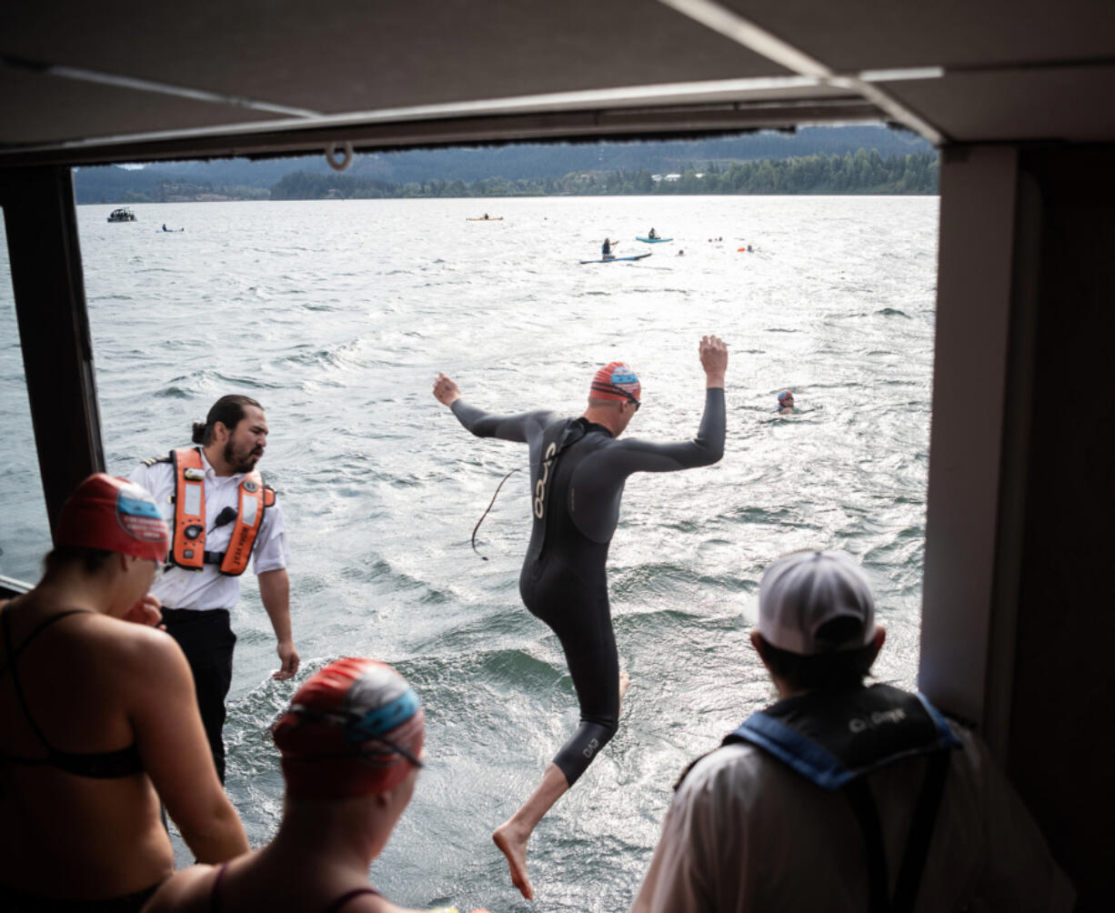 Swimmers jump off the sternwheeler Columbia Gorge at the starting line Monday, during the 80th Columbia River Cross Channel Swim in Cascade Locks, Ore.