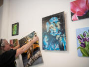 Christine A. Richardson, executive director of theARTScentered, hangs an owl painting Thursday at the Vancouver Arts Hub in the former Vancouver Community Library.