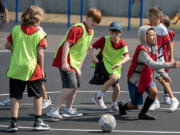 Hazel Dell Elementary School fifth-graders battle for control of the ball during a futsal game at recess Thursday afternoon.