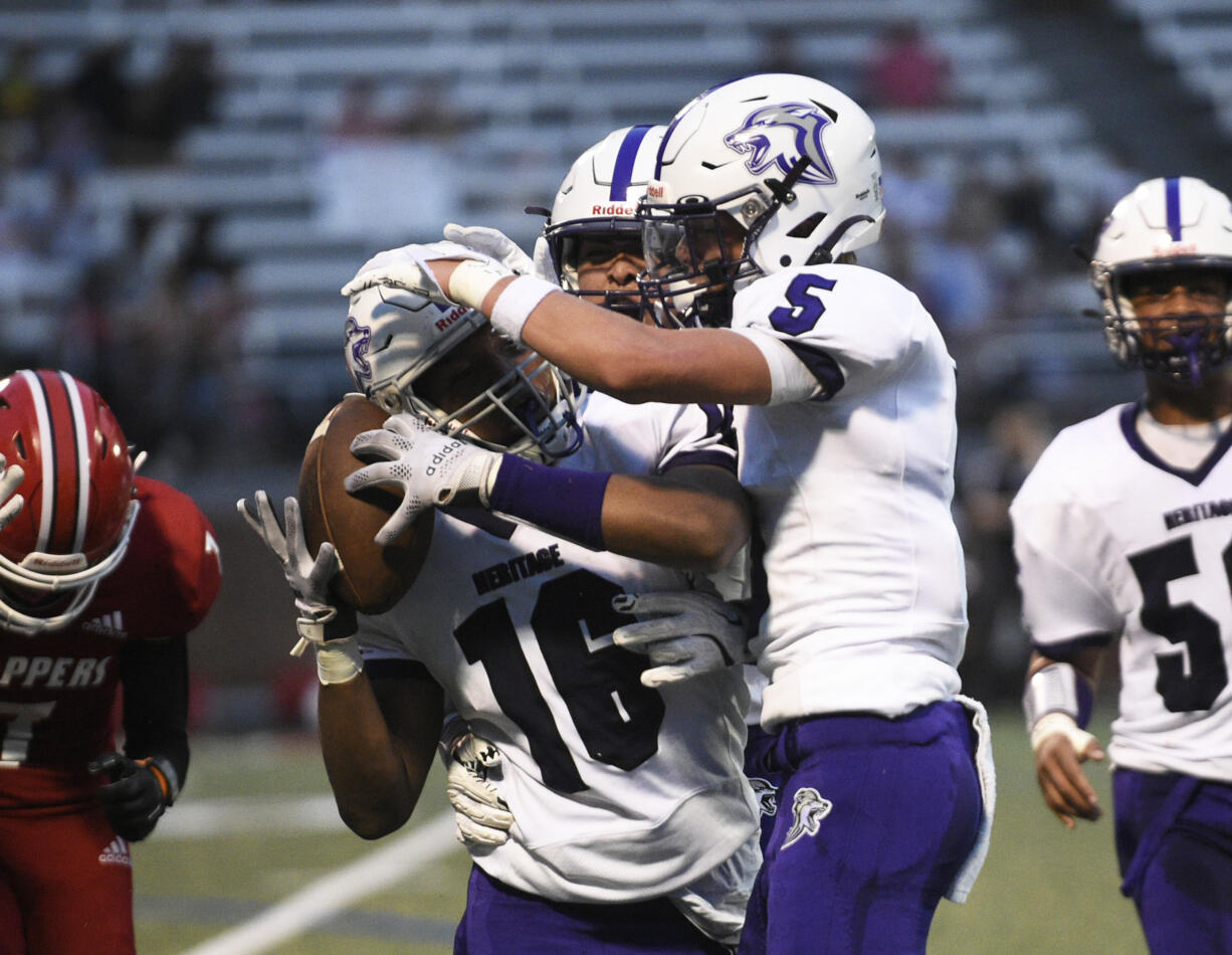 Isaiah James (16) of Heritage celebrates his interception with teammate Jacob Karpyuk during a non-league football game against Fort Vancouver at Kiggins Bowl in Vancouver on Saturday, Sept. 7, 2024.