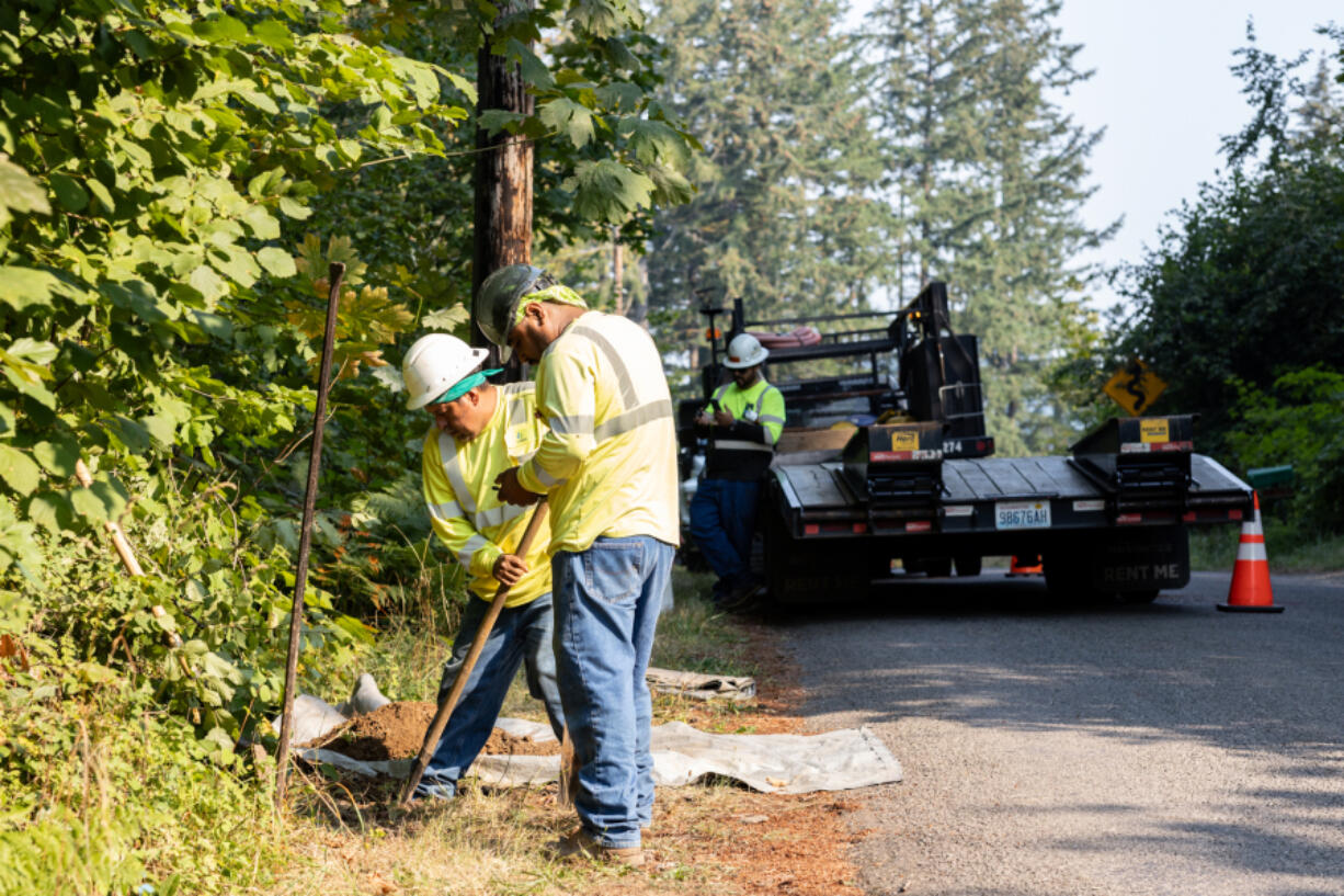 Salom&eacute; Hernandez, left, and Fausto Ventura dig a hole for the beginning of the new conduit run. Comcast won a contract with Clark County to expand broadband internet infrastructure to 500 homes and businesses in rural parts of the county.