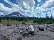 Dr. Emily Montgomery-Brown, from the Cascades Volcano Observatory in Vancouver, places monitoring equipment near Three Sisters. (Contributed by U.S.