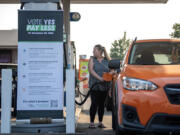 Vancouver resident DeAnna Hathaway fills up her tank while prices were temporarily lowered at a Chevron gas station along Northeast Andresen Road on Friday morning. Let&rsquo;s Go Washington hosted three gas station events to highlight the Initiative 2117 campaign to repeal the state&rsquo;s Climate Commitment Act. The organization slashed the cost of gasoline to reflect the national average and paid the difference on every gallon of gas sold during the event.