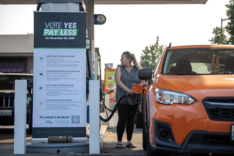 Vancouver resident DeAnna Hathaway fills up her tank while prices were temporarily lowered at a Chevron gas station along Northeast Andresen Road on Friday morning. Let&rsquo;s Go Washington hosted three gas station events to highlight the Initiative 2117 campaign to repeal the state&rsquo;s Climate Commitment Act. The organization slashed the cost of gasoline to reflect the national average and paid the difference on every gallon of gas sold during the event.