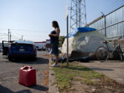 Amanda Cowan/The Columbian
Camper Becky Hoofnagle stands in the harsh sunlight while talking about the challenges of living outdoors during extreme heat in downtown Vancouver on Thursday morning. People living in their vehicles are especially vulnerable during the heat, forecasted to reach 101 degrees on Thursday.