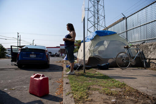 Amanda Cowan/The Columbian
Camper Becky Hoofnagle stands in the harsh sunlight while talking about the challenges of living outdoors during extreme heat in downtown Vancouver on Thursday morning. People living in their vehicles are especially vulnerable during the heat, forecasted to reach 101 degrees on Thursday.