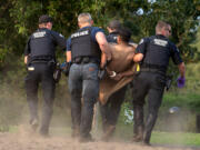 Members of the Vancouver Police Department carry a naked man up the beach during a mental health episode that brought paramedics, firefighters and police officers to Wintler Park under an excessive heat warning on Thursday afternoon, Sept. 5, 2024.