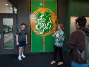 Washington School for the Deaf Superintendent Shauna Bilyeu, center, speaks using American Sign Language with students Casey Lewandowski, left, and Angel Castro, right, about a piece of the school&rsquo;s old gymnasium floor on display in the new gymnasium. The floor, she said, is a critical piece of the school&rsquo;s history, as sports games are often a huge source of community.