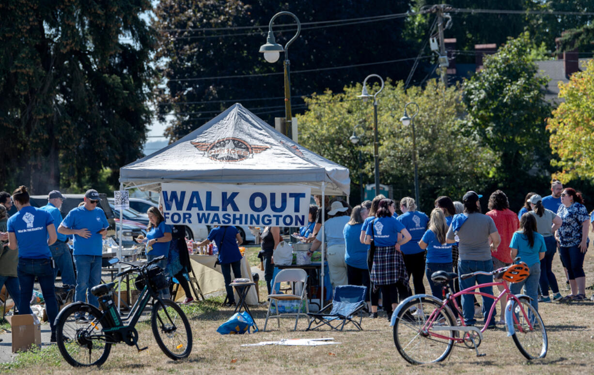 Union members and supporters gather for a barbecue at Mill Plain Park during a walkout Tuesday afternoon. Clark College classified union members walked out to raise awareness of stalled bargaining with the state.