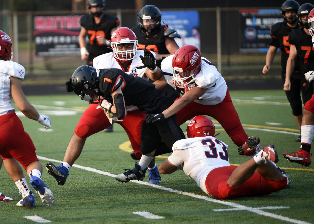 Owen Mereen (1) of Battle Ground is brought down by Eisenhower defenders Daniel Machuca (left), Harley Lua (center) and Eddie Herrera (33) during a non-league football game at District Stadium in Battle Ground on Friday, Sept. 6, 2024.