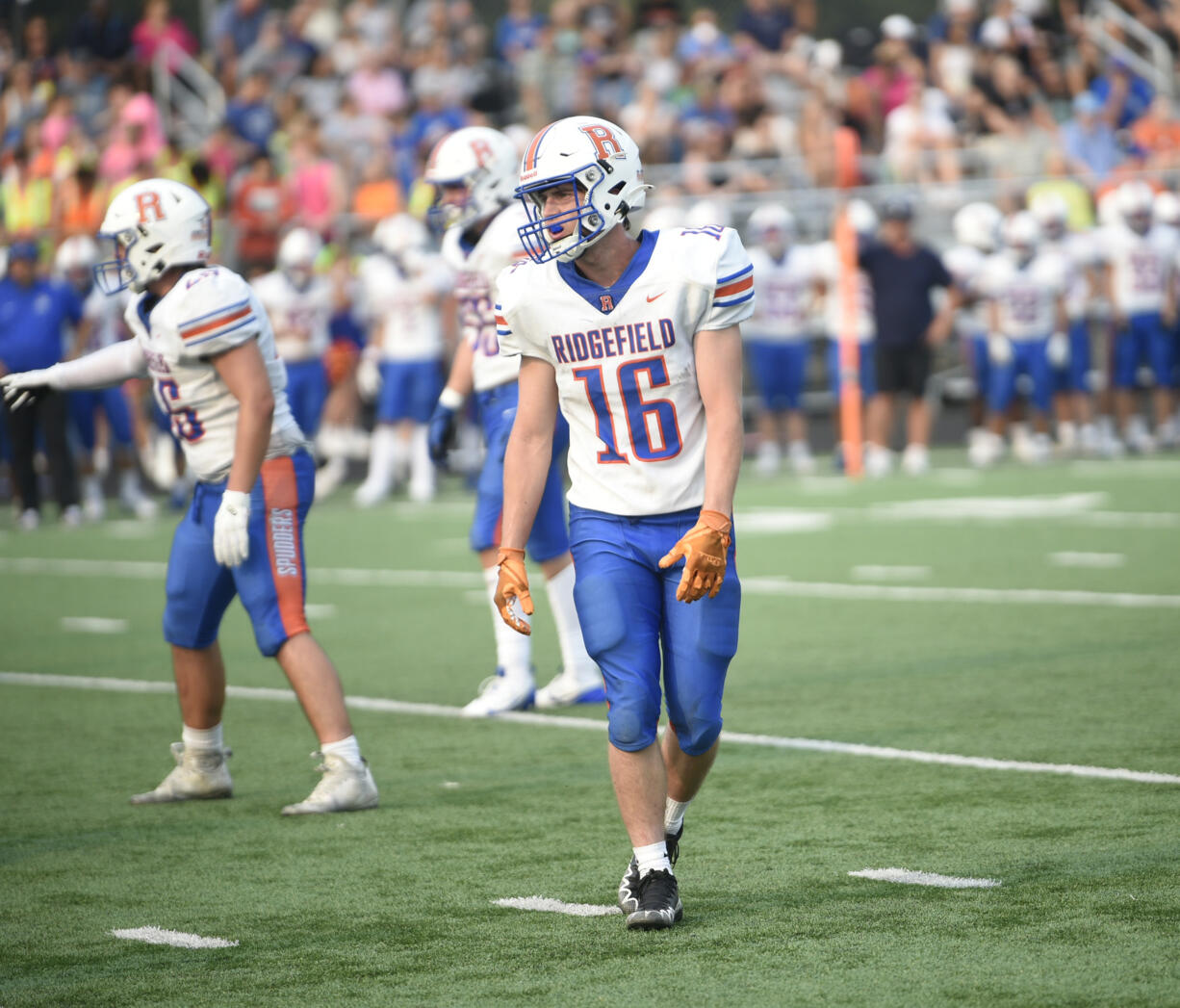 Jake Olsen (16) of Ridgefield heads to his defensive position against Prairie during a non-league football game at District Stadium in Battle Ground on Saturday, Sept. 7, 2024.