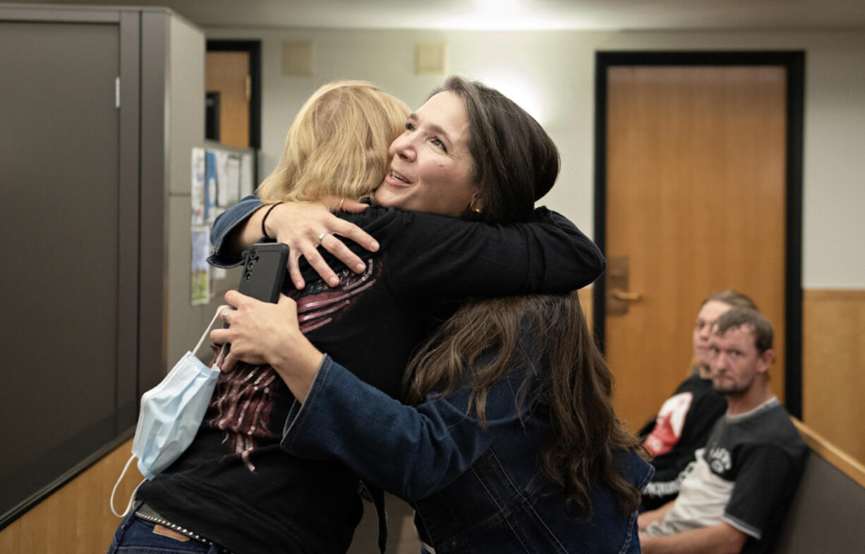 Debbie Akers of Recovery Cafe, left, shares a hug with Clark County Superior Court Adult Drug Court graduate Jennifer Miller on Thursday before Miller speaks to the group at the Clark County Courthouse. Superior Court is celebrating 25 years of hosting a drug court, which allows those who graduate the treatment court to have their criminal cases dismissed.