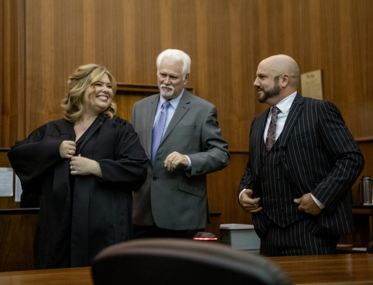 Clark County Superior Court Judge Christine Hayes, left, smiles with father Jay Hayes, center, and husband Ryan Busby on Friday during her swearing-in ceremony at the Clark County Courthouse. Gov. Jay Inslee appointed Hayes to fill the newly created 12th Superior Court judicial department.