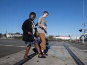 Vancouver resident Abby Griffith, left, who is blind, navigates train tracks while leaving the Vancouver train station with Kail Hibbs of the city of Vancouver on Monday afternoon. The journey took place ahead of the city&rsquo;s Week Without Driving challenge to highlight the importance of mobility access in the region.