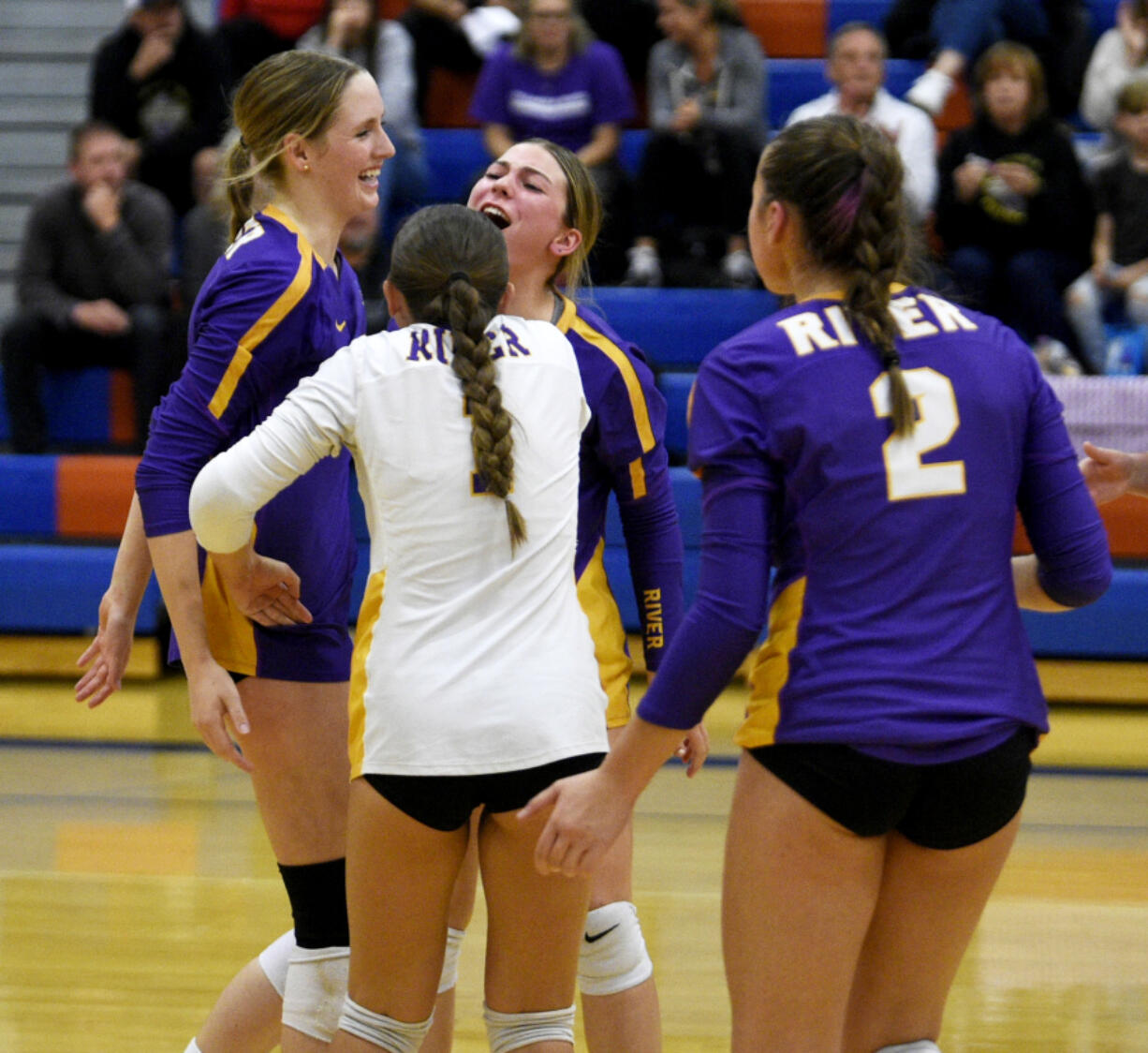 Columbia River's Sydney Dreves, left, celebrates a point with teammates during a Class 2A Greater St. Helens League volleyball match against Ridgefield on Tuesday, Sept. 17, 2024 at Ridgefield High School.