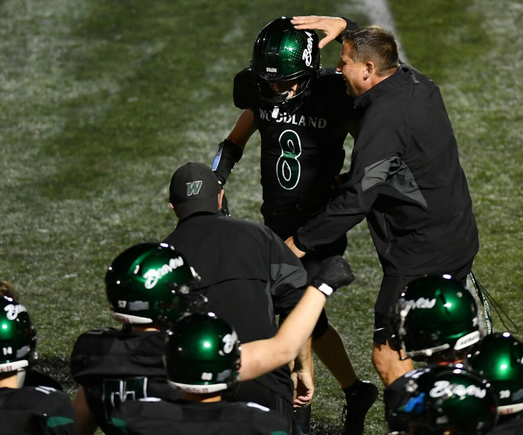 Woodland head coach Glen Flanagan, right, pats junior Josiah Graham (8) on the head after Graham intercepted a pass Friday, Sept. 20, 2024, during Woodland’s 12-0 win against Washougal at Woodland High School.