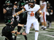 Washougal junior Royce Jones (8) stiff arms would-be tackler Woodland junior Karsen Northcut (3) on Friday, Sept. 20, 2024, during Washougal’s 12-0 loss to Woodland at Woodland High School.