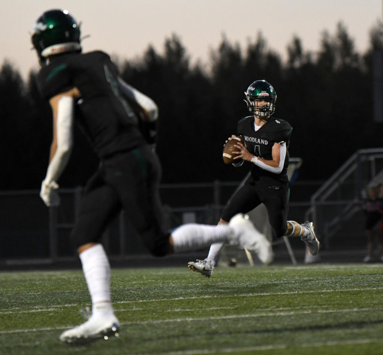 Woodland quarterback Elijah Andersen (4) looks for an open receiver Friday during Woodland&rsquo;s 12-0 home win over Washougal.