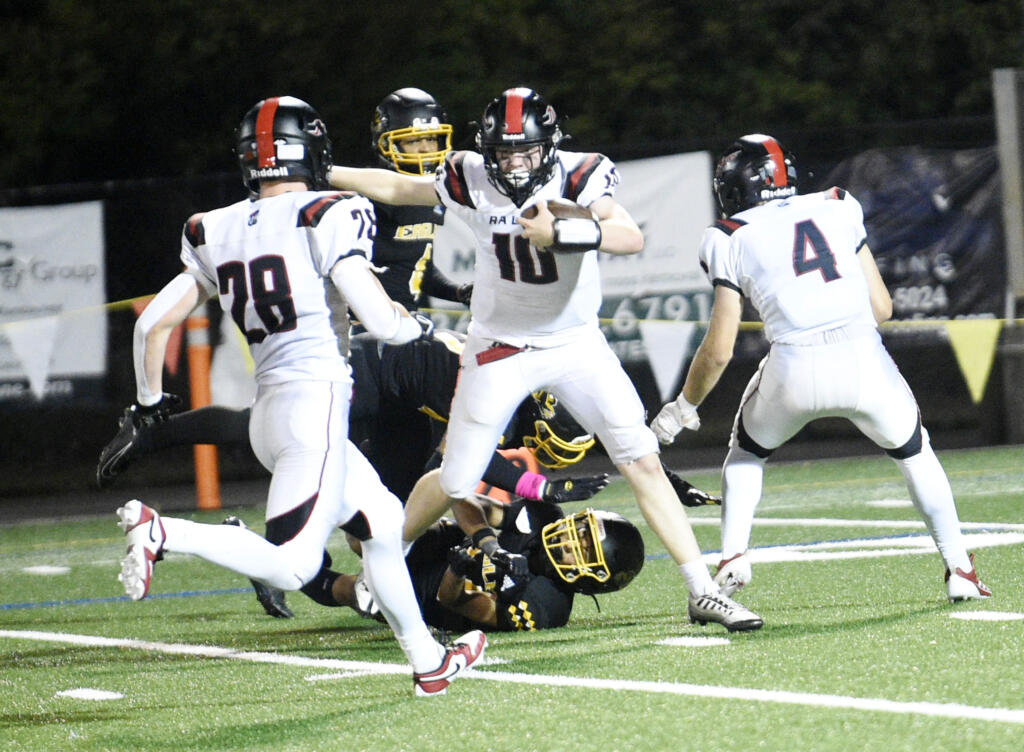 R.A. Long quarterback Jaxson Rivenes (10) spins out of a tackle against Hudson's Bay in a 2A Greater St. Helens League football game at Kiggins Bowl on Friday, Sept. 20, 2024.