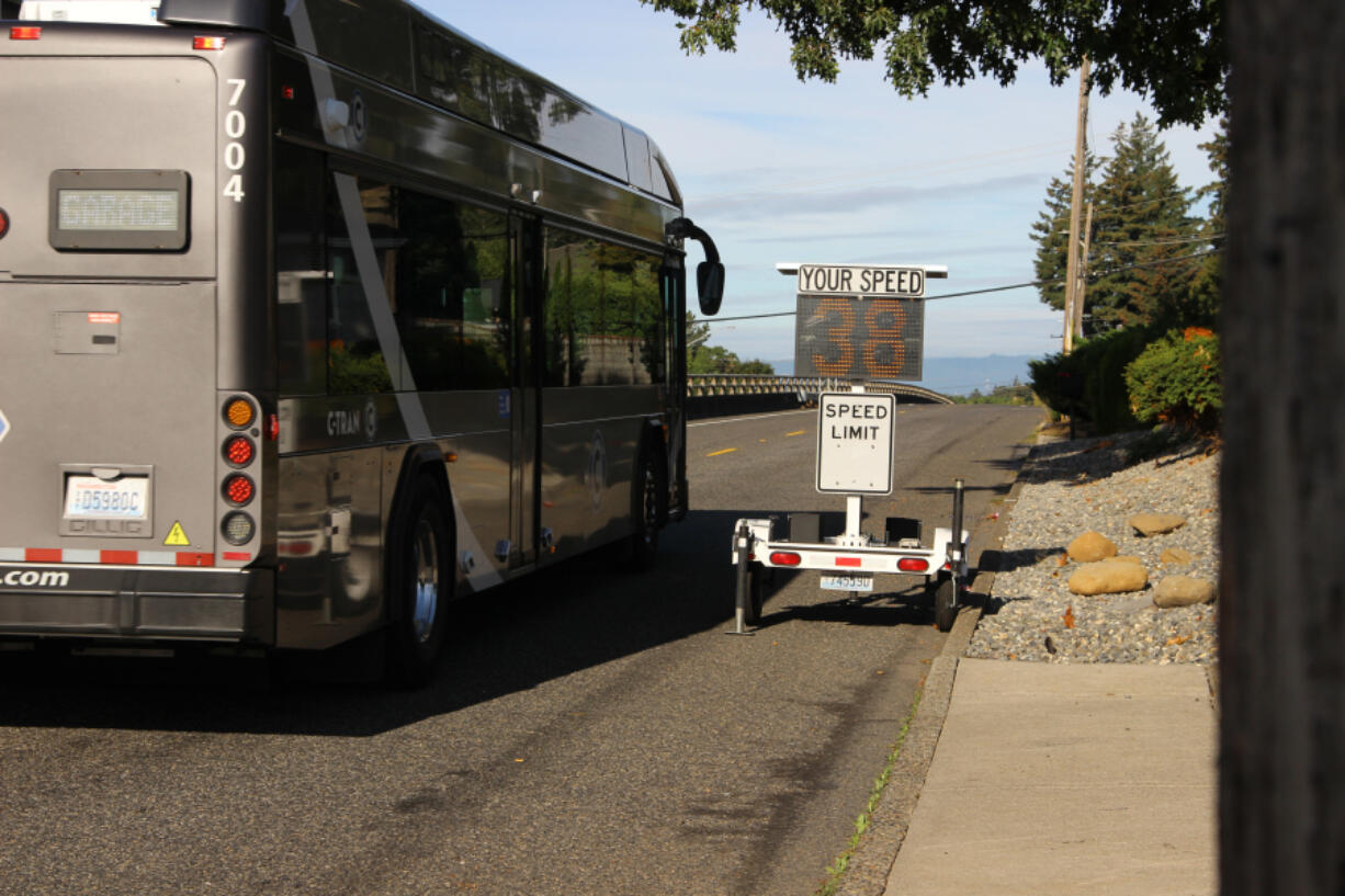 A bus travels past a speed sign on East Evergreen Boulevard. When the sign was placed in the area last week, it mistakenly displayed &ldquo;ticket sent&rdquo; to speeders.